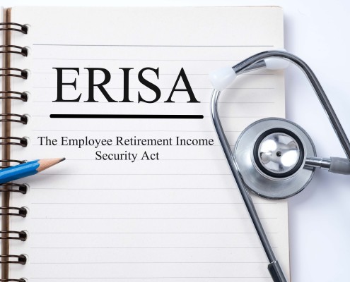 Stethoscope on notebook and pencil with ERISA (The Employee Retirement Income Security Act) words as medical concept.