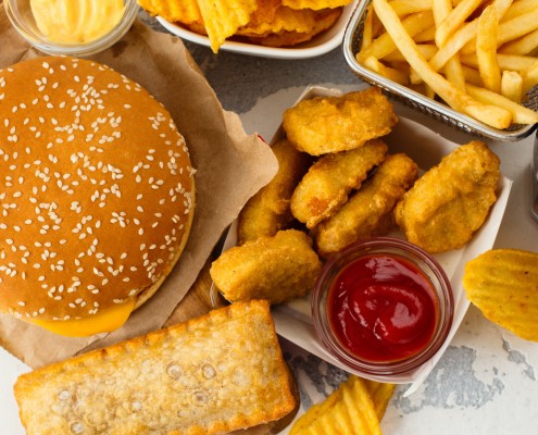 Junk food on white table. Fast carbohydrates not good for health, heart and skin