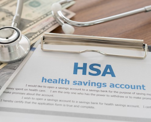 health savings account HSA concept with application form,dollar money, stethoscope on desk.